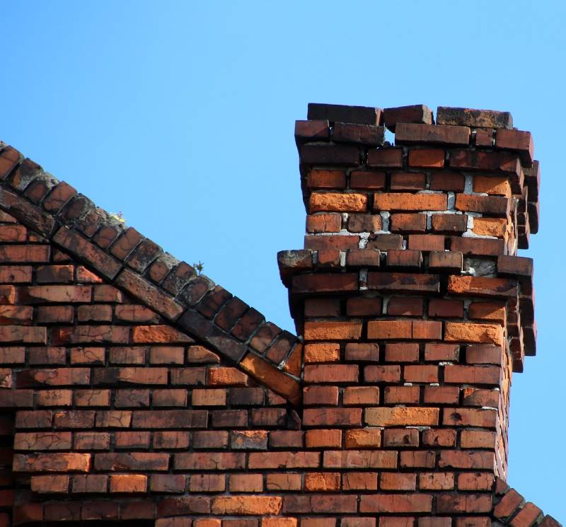 Damaged chimney on an Beverly home showing cracks and missing mortar